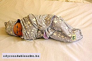 Enrolar bebê na manta e deitar de lado